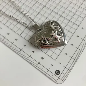 Silver heart locket necklace with bat pendant, gothic style jewelry for daily wear.