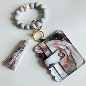 Portafoglio porta carte stampa marmo con braccialetto perle silicone e portachiavi nappina dettaglio