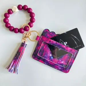 Portacarte con stampa galassia, braccialetto di perle in silicone e nappa in pelle.
