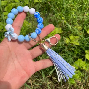 Detailed view of the blue and white beaded keychain bracelet with a stylish PU leather tassel.