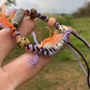 Pulsera de cuerda trenzada de estilo tibetano hecha a mano con cuentas étnicas detalladas.