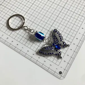 Vintage rhinestone butterfly keychain with evil eye bead, metal ring pendant for bags.