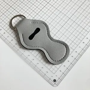 Détail de porte-clés étui à lèvre en néoprène gris, housse portable pour gel hydroalcoolique.