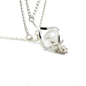 Detail view of a vintage dandelion glass ball necklace with twisted silver chain and pendant.
