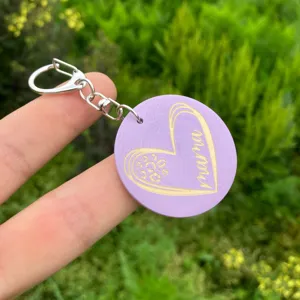 Detailed close-up view of the purple wooden keychain featuring engraved heart and mama text.