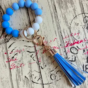 Detailaufnahme des blau-weißen Silikonperlen-Schlüsselanhänger-Armbands mit PU-Quaste.