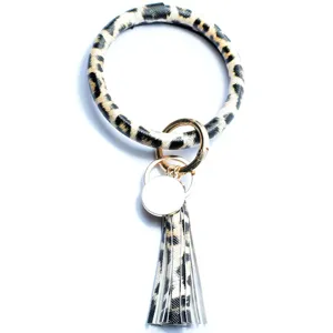 Detailed view of leopard print PU leather wristlet keychain with tassel and metal round disc.