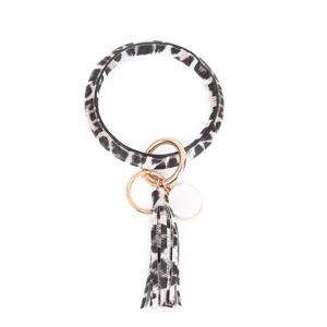 Detailopname van de luipaard PU leer armband sleutelhanger met gouden ringen en een mooie kwast.