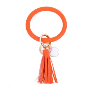 Oranje PU lederen kwast sleutelhanger detail met gladde textuur en metalen ringen vooruit.