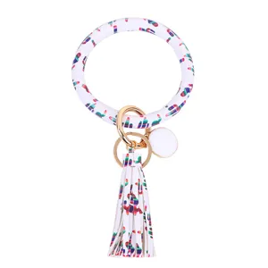 Close-up detail van witte PU lederen ronde armband sleutelhanger met kleurrijke cactusprint.