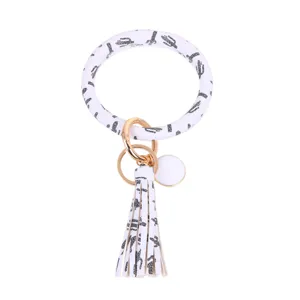 Ronde PU lederen armband sleutelhanger met stijlvolle cactus luipaardprint en kwast detail.