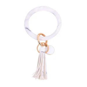 Wit marmer print PU leer ronde armband sleutelhanger met stijlvolle kwast en gouden details.