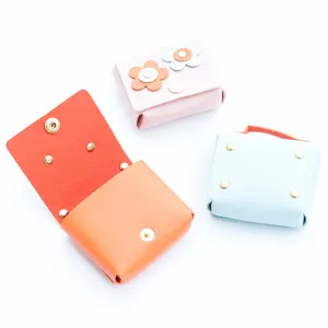 Leather mini earphone pouch detail showing exquisite buttons and cute flower charms.