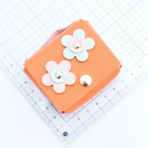 Handmade leather flower mini coin purse and earphone case with snap closure and vibrant orange color.