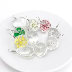 Detailed view of handmade clear resin dried flower pendants featuring dandelions and clovers.