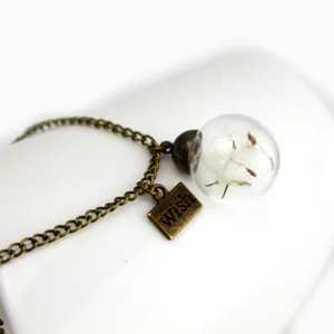 Dandelion glass ball pendant necklace detail showing bronze chain and wish tag charm.