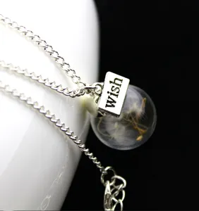 Dandelion glass ball necklace detail view, featuring a clear sphere and wish tag.