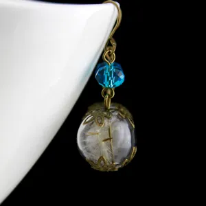 Collana pendente in vetro con sfera di fiore di tarassaco essiccato naturale e perla blu.