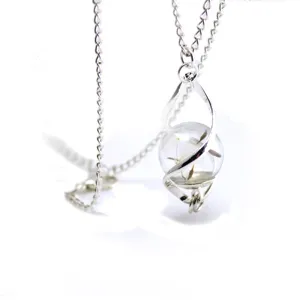 Detail view of dandelion crystal glass necklace with silver chain and spiral pendant design.