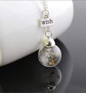 Close-up of a dandelion seeds wish bottle glass ball necklace with wish charm forest style detail