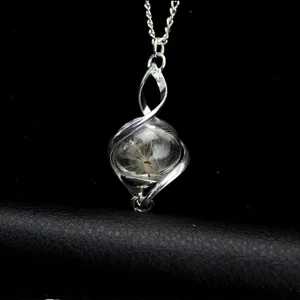 Detailed view of silver twisted cage necklace featuring glass sphere with dandelion seed.