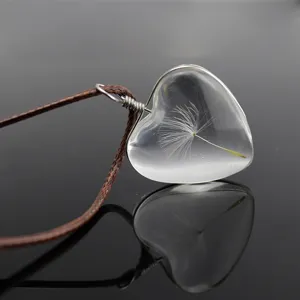 Clear heart shaped dandelion seed pendant close up, exquisite transparent resin necklace jewelry detail.