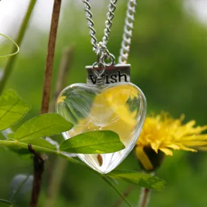 Dandelion seed glass heart pendant necklace close up showing delicate flower element.