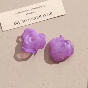 Close-up of ice-clear purple acrylic rose flower DIY jewelry patches for earrings and crafts.
