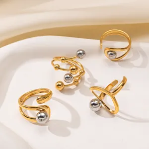 Detaillierte Nahaufnahme von zweifarbigen geometrischen offenen Ringen aus Edelstahl mit Kugeln.