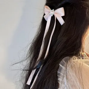 Sweet pink ribbon bow hair clip with rhinestone star detail and long tails for cute styles.