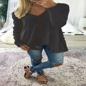 Detail view of women's dark grey ribbed V-neck long sleeve sweater with irregular hem.