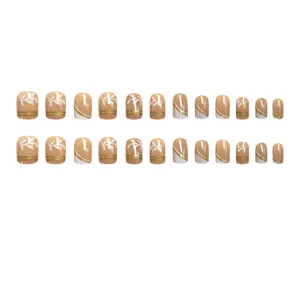Primo piano dettagliato di eleganti unghie finte nude con foglie bianche e linee dorate.