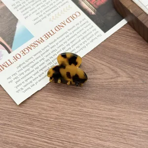 Close-up detail of mini tortoiseshell acetate hair claw clip for elegant hairstyles