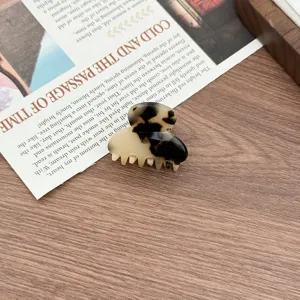 Detail shot of a small acetate hair claw clip with a chic tortoiseshell pattern design.