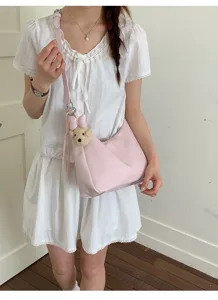 Detailed view of the pink shoulder crossbody bag featuring a cute bear charm for daily wear.
