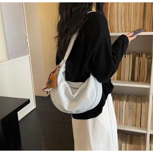 Detailed view of the white minimalist hobo shoulder bag with cute pendant for daily commute.