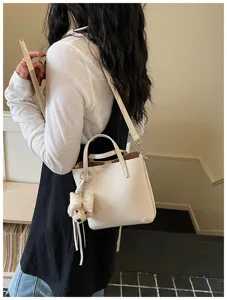 Chic minimalist faux leather tote bag with cute bear charm, elegant casual shoulder handbag.