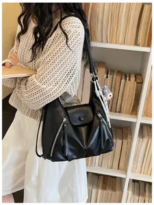 Stylish black PU leather shoulder bag for women with multiple zippers and trendy cute keychain.