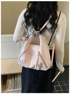 Detailed view of stylish pink convertible tote backpack worn on model, showing sleek design.
