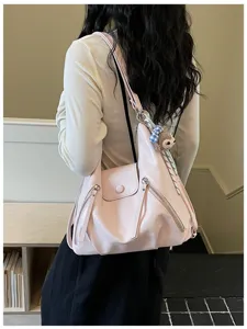 Pink leather shoulder bag for women, trendy slouchy hobo bag with zipper pockets and charm.