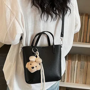 Chic black commuter tote bag for women, large capacity shoulder crossbody with cute charm.