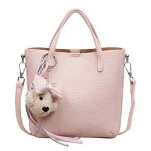 Pink leather tote bag for women, chic commuter shoulder crossbody bag with bear charm.