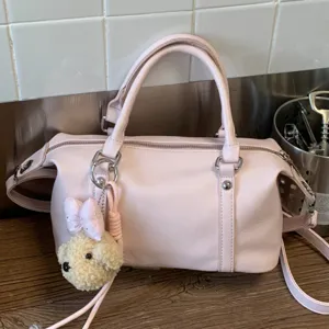 Chic pink pillow handbag for women, versatile sweet crossbody bag with cute bear pendant.