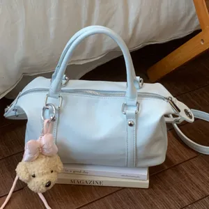 Stylish light blue bowling shoulder bag with cute bear pendant, trendy PU leather handbag.