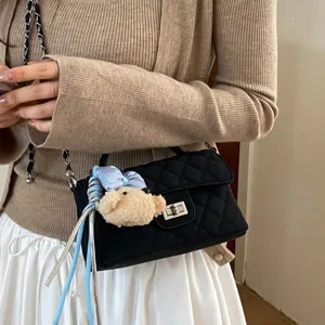 Elegante borsa a tracolla trapuntata nera da donna con ciondolo orsetto e catena chic.