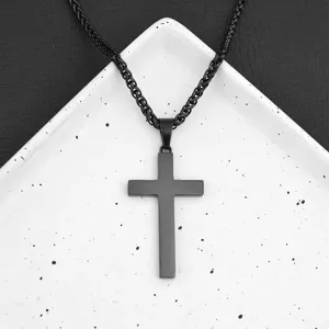 Vista dettagliata di una collana con ciondolo a croce nera su vassoio bianco, design elegante.