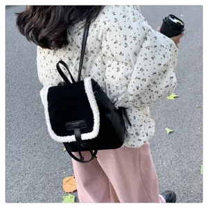 Close-up detail of stylish black backpack with white shearling trim, perfect daily casual wear.