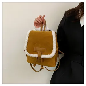 Brown suede backpack with fluffy white sherpa trim, stylish winter mini bag detail view.