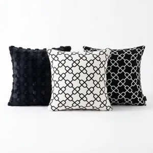 Detail view of modern minimalist black and white geometric pattern throw pillow set texture.
