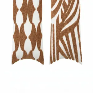Cream tufted lumbar pillow cover featuring abstract geometric and stripe designs for home decor.